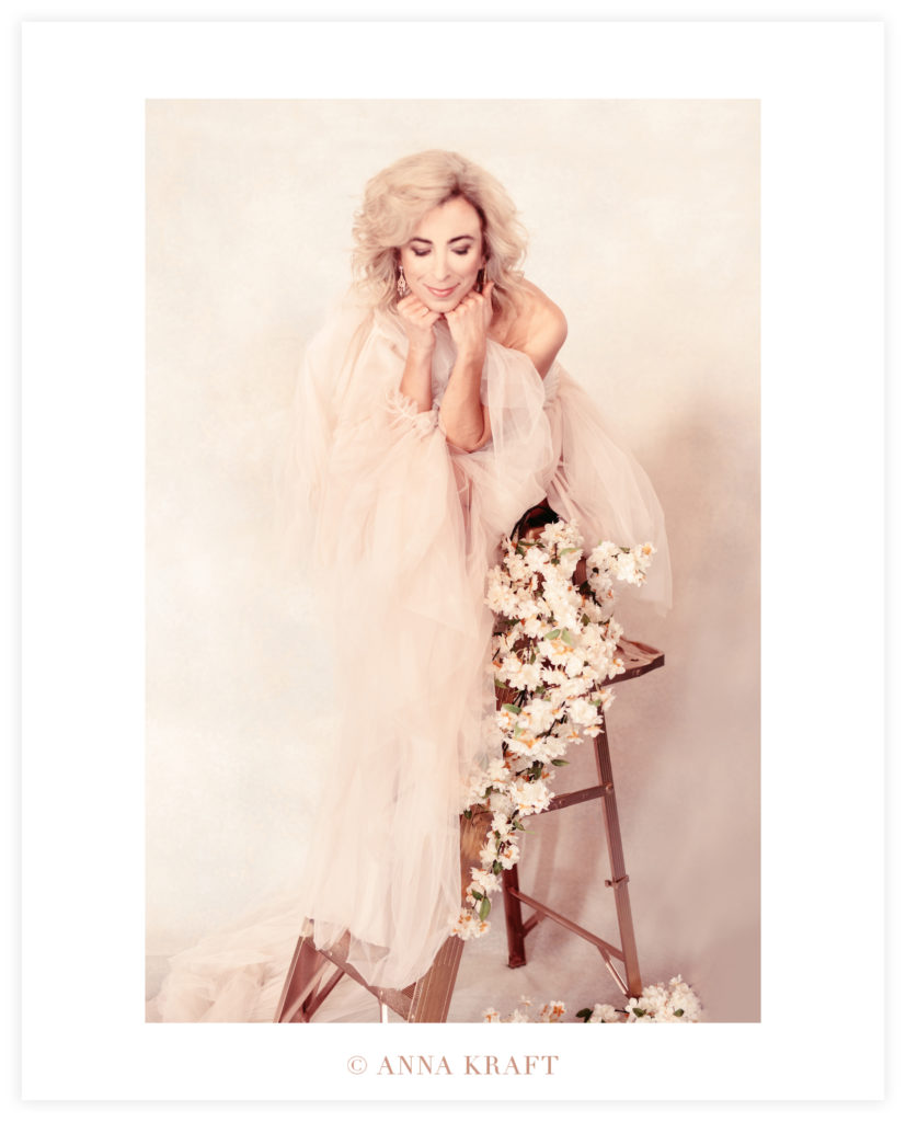 Dana perched on flower-covered ladder in tulle gown
30 over 30 photoshoot interview